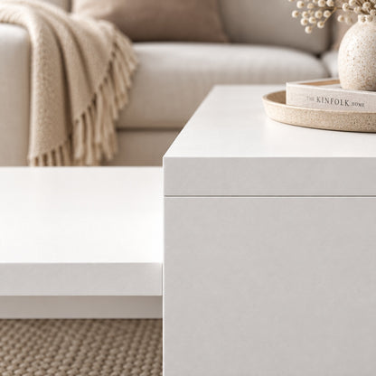 Table basse blanche design en gros plan, finition mate et lignes minimalistes dans un intérieur chaleureux.