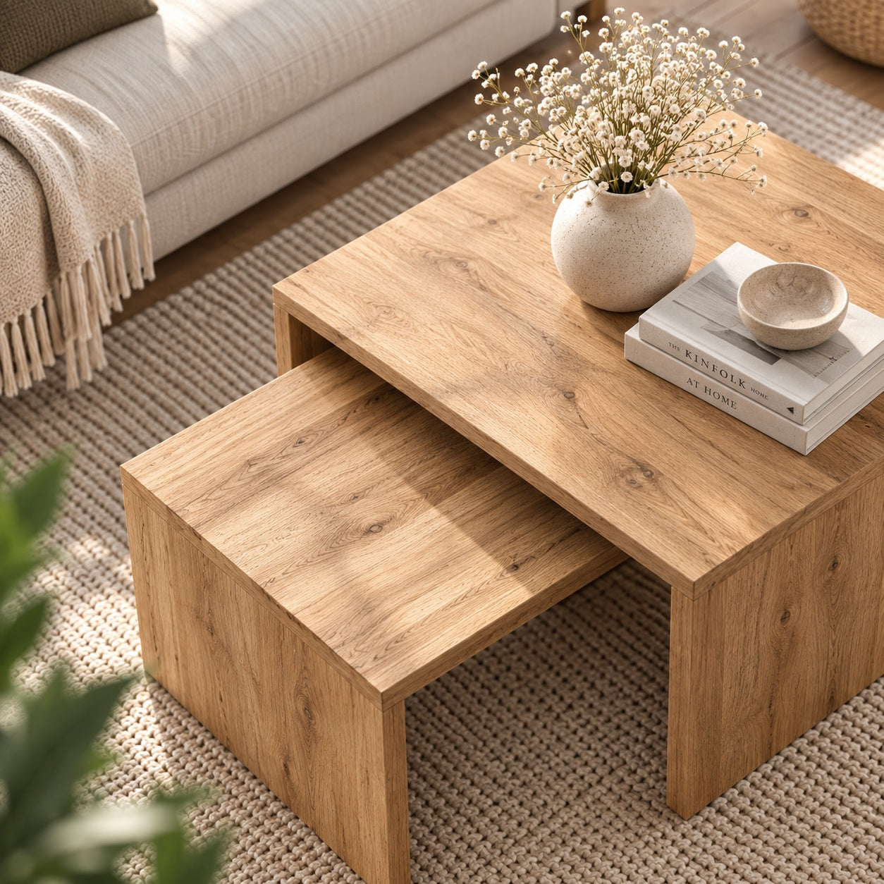 Table basse en bois design vue en plongée, avec tables gigognes et décoration naturelle dans un salon lumineux.