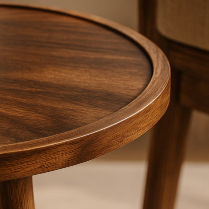 Gros plan du plateau d’une table basse ronde en bois, grain naturel et finition élégante.