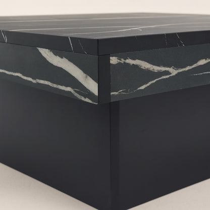 Détail du plateau effet marbre noir d’une table basse design avec rangement caché.