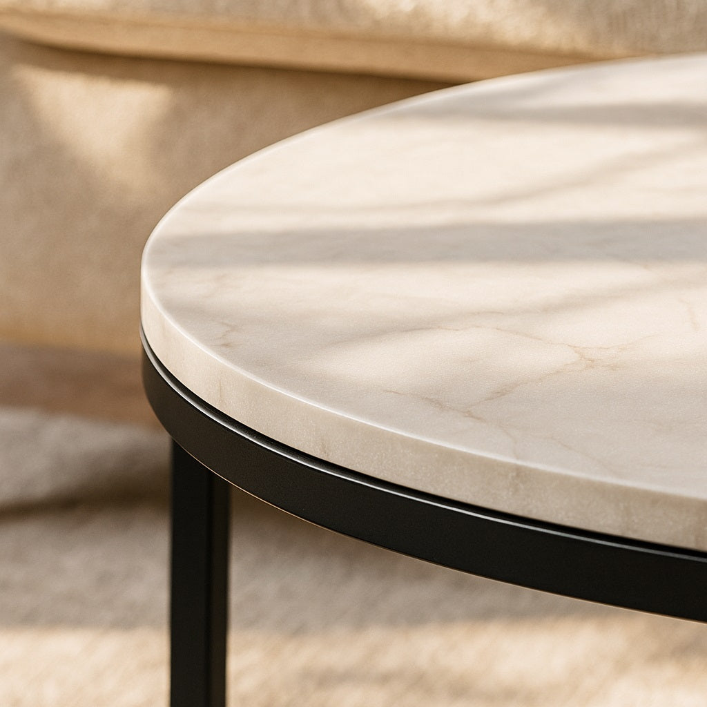 Gros plan sur le plateau marbre blanc et piètement métal noir de la table basse ronde.