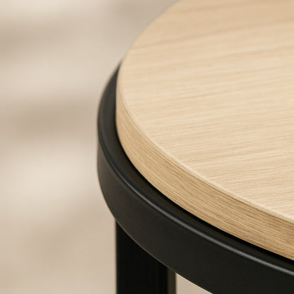 Détail du plateau en bois d’une table basse ronde relevable, finition élégante et structure métal noire.