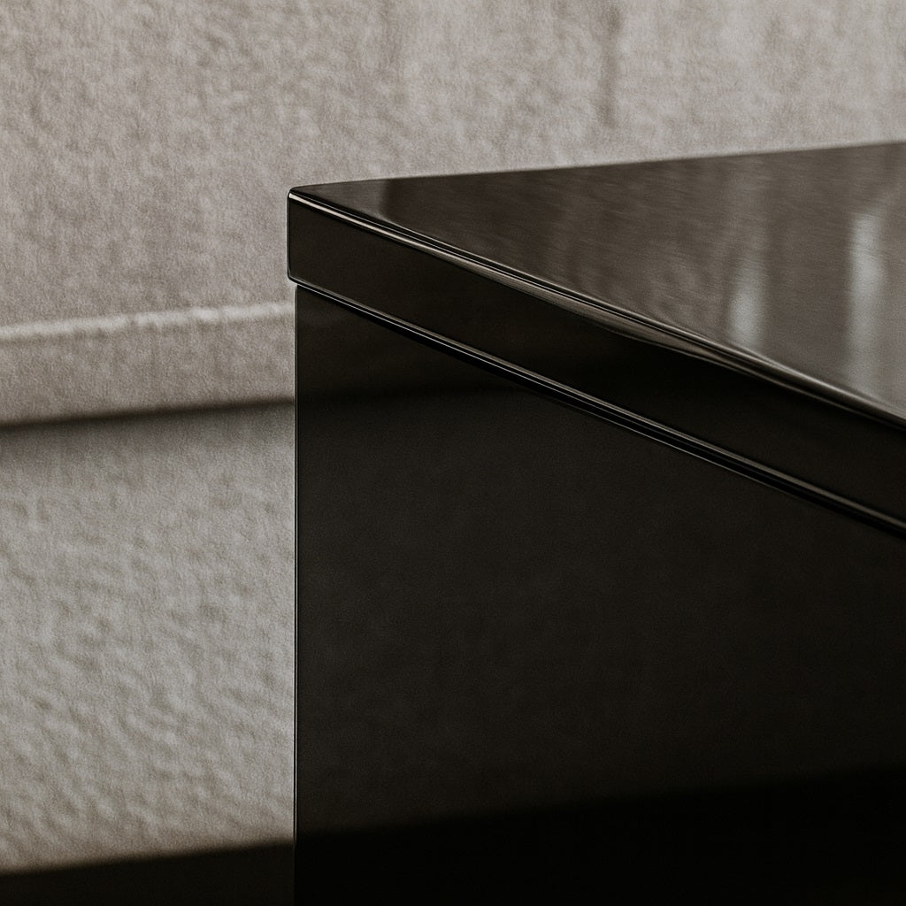 Détail du plateau brillant d’une table basse relevable noire, finition laquée haut de gamme.