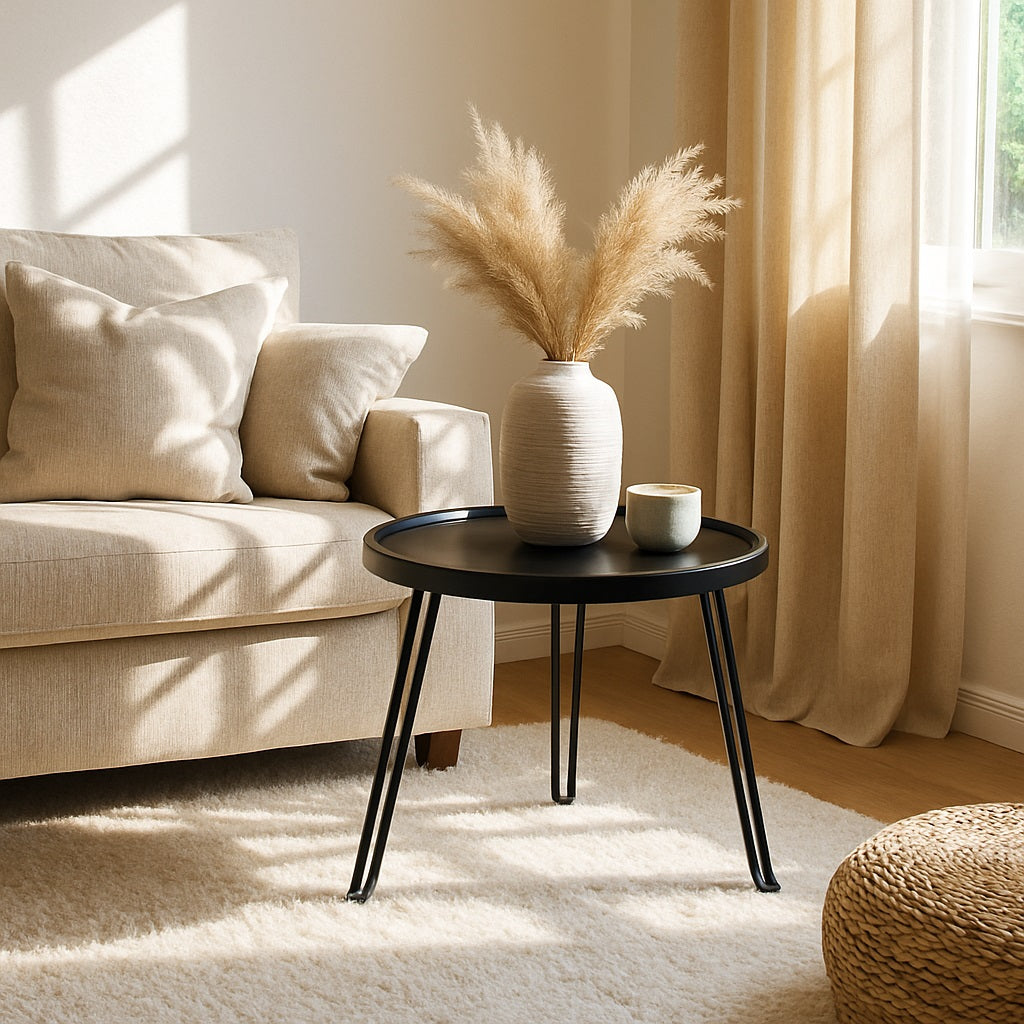 Table basse ronde noire Arcus dans un salon lumineux, style moderne et chaleureux.
