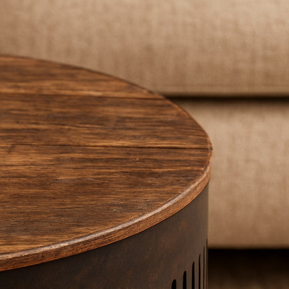Zoom sur la table basse ronde style industriel avec plateau bois texturé et base en métal foncé.