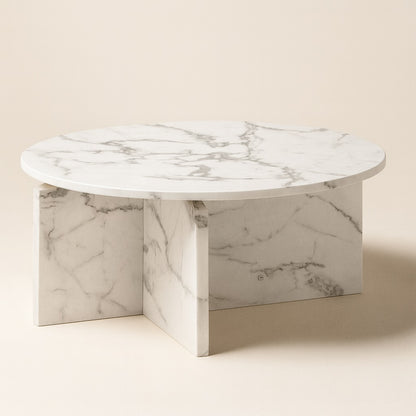 Table basse ronde en marbre blanc, design moderne avec piètement croisé élégant, idéale pour un salon contemporain.