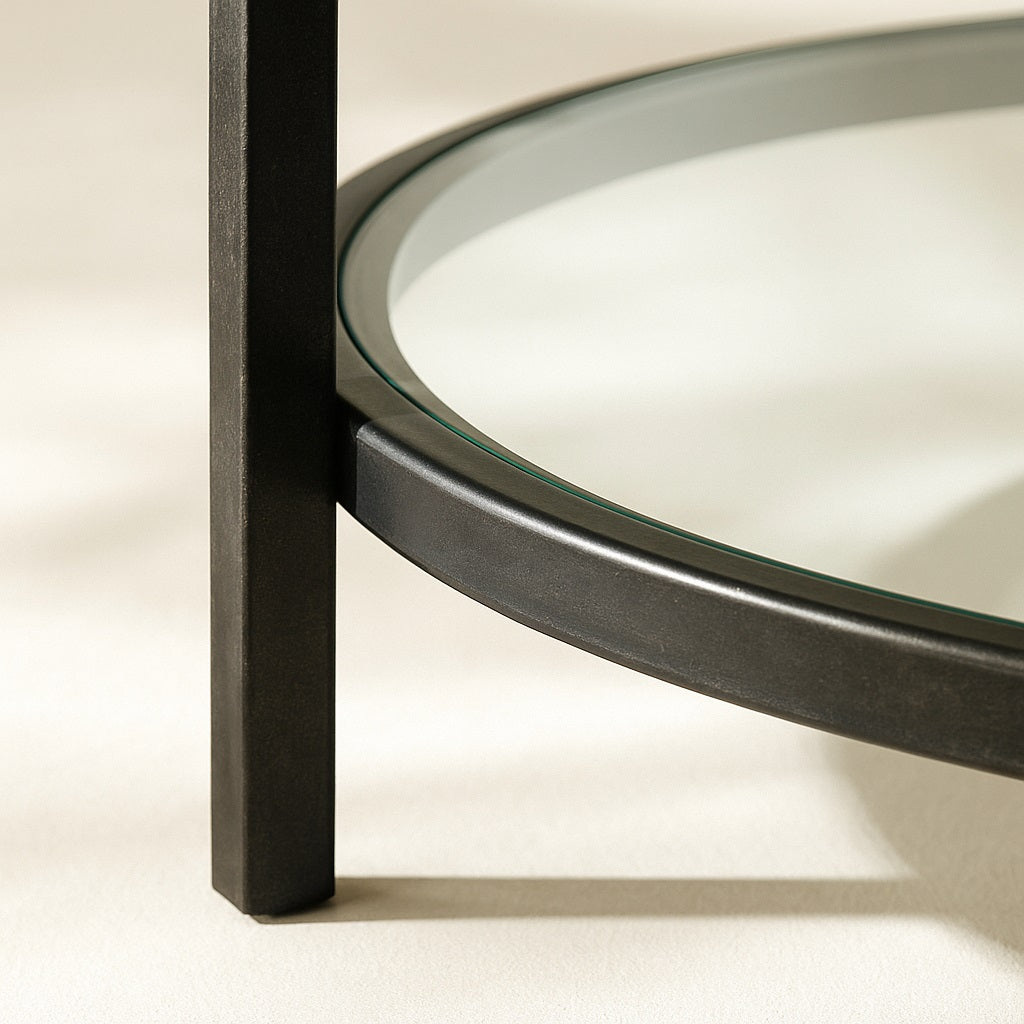 Zoom sur l’étagère en verre de la table basse ronde marbrée NOLYA, structure métal noir.