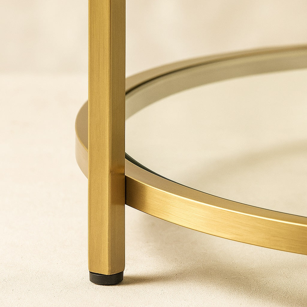 Zoom sur le plateau inférieur en verre de la table basse marbrée NOLYA, finition dorée brillante.