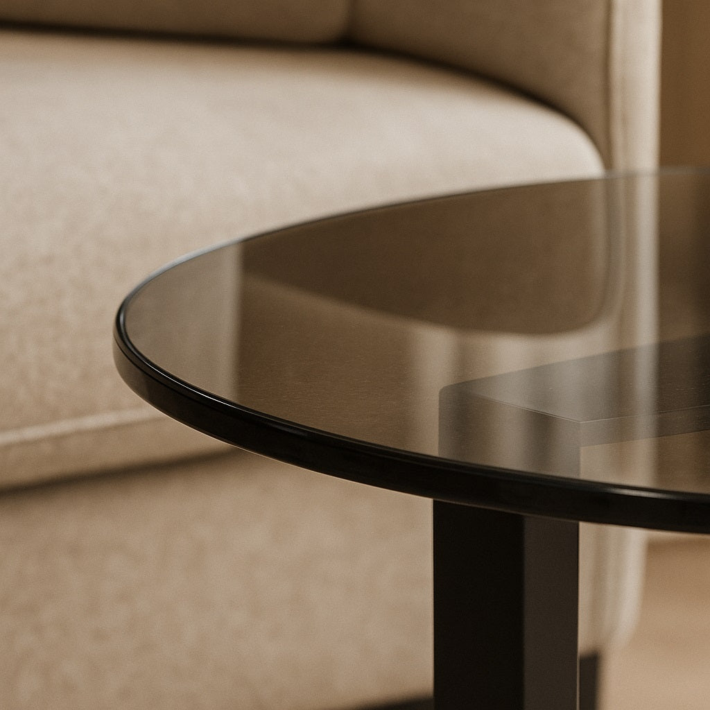 Détail du plateau de table basse ronde en verre fumé dans salon contemporain.