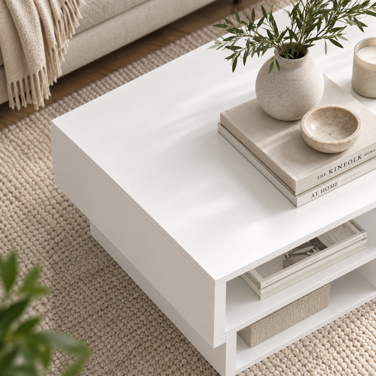 Table basse blanche design vue du dessus, avec rangements ouverts et décoration élégante dans un salon.