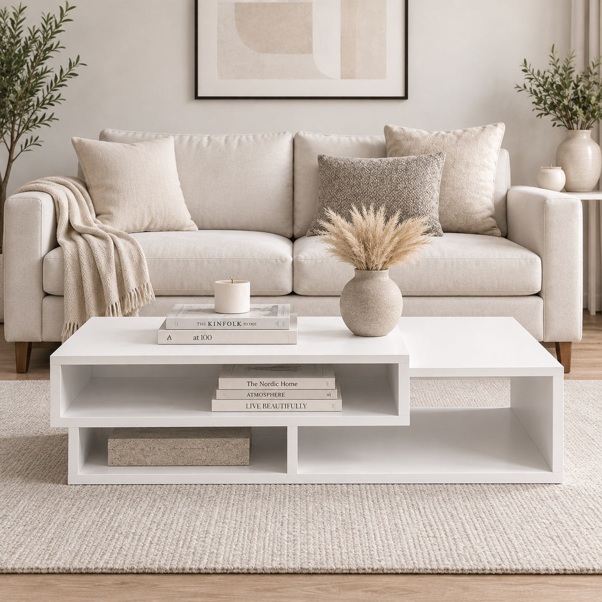 Table basse blanche design avec niches de rangement, vue de face dans un salon moderne aux tons naturels.
