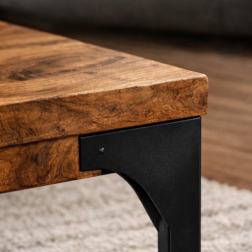 Zoom sur le piètement métal noir d’une table basse en bois, alliance du bois naturel et du style industriel.