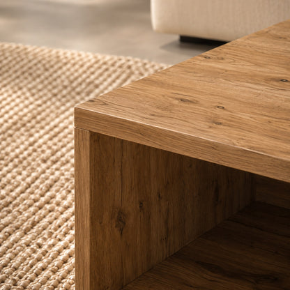 Gros plan haute définition sur table basse en chêne artisanal, texture bois détaillée et tapis tissé en arrière-plan.