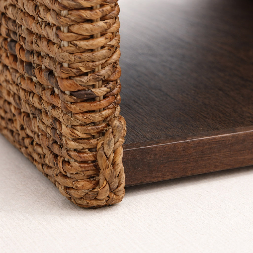 Détail de la table basse en bois montrant le tressage artisanal et le plateau foncé, table basse de salon haut de gamme.