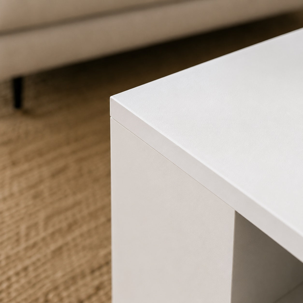 Gros plan sur la finition mate de la table basse blanche design, mettant en valeur la qualité des matériaux.