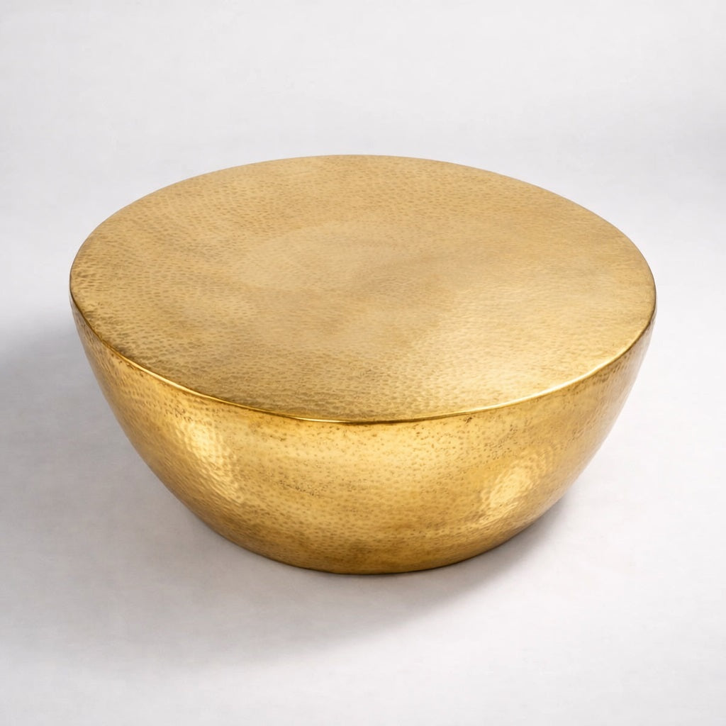 Table basse design ronde en métal doré martelé, silhouette organique et style contemporain.
