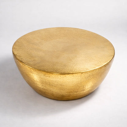 Table basse design ronde en métal doré martelé, silhouette organique et style contemporain.