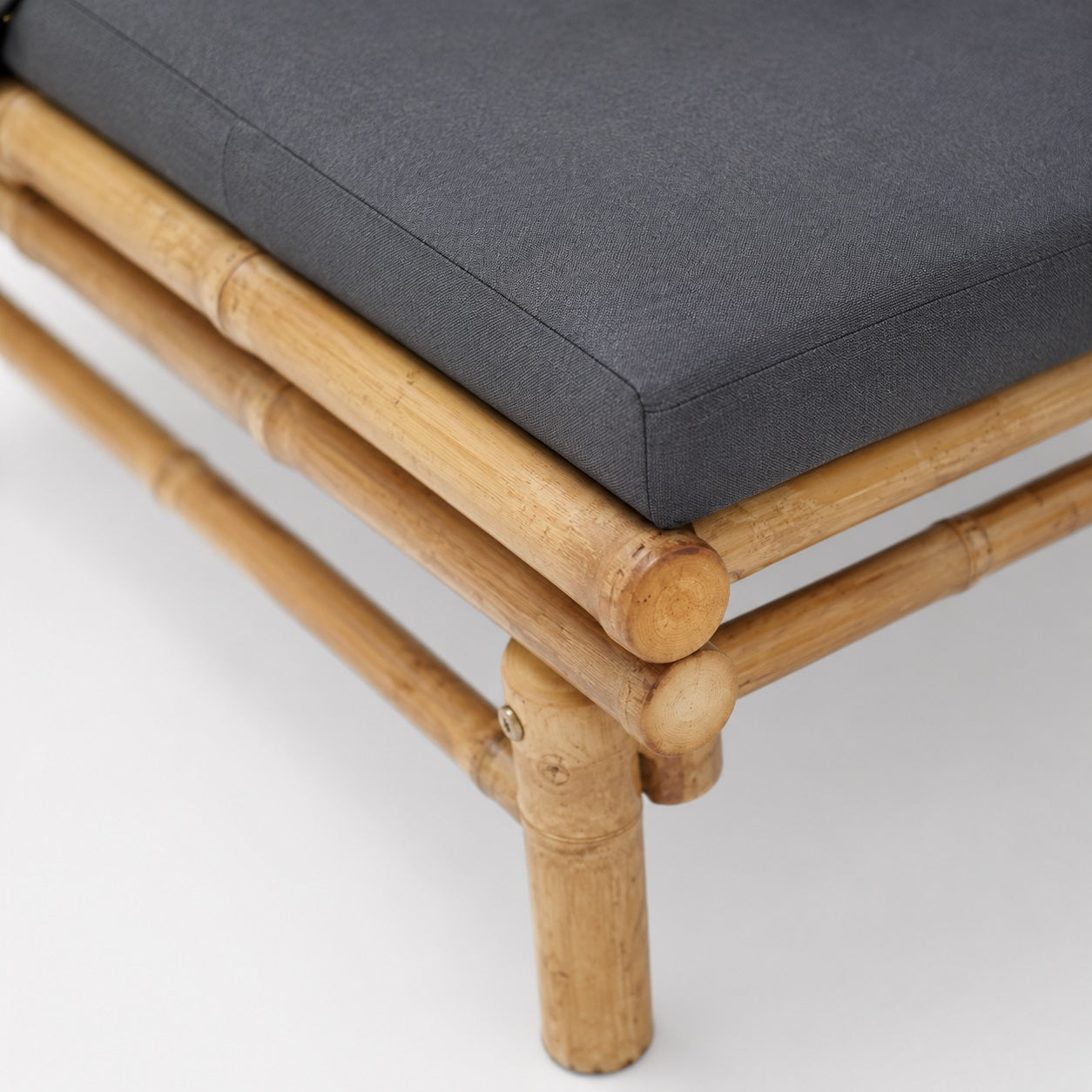 Détail coussin gris et structure bambou, table basse d'extérieur et salon de jardin design