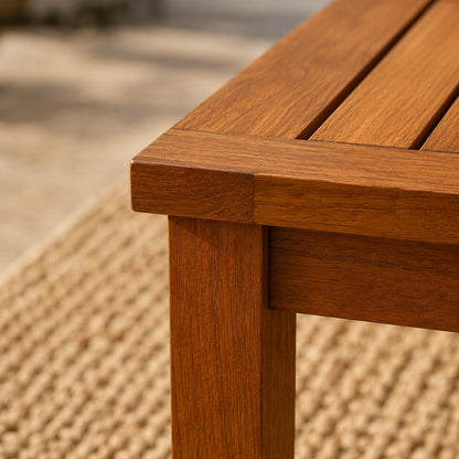 Gros plan d'une table basse de jardin en bois avec texture détaillée, finition soignée et assemblage robuste, ambiance extérieure élégante.