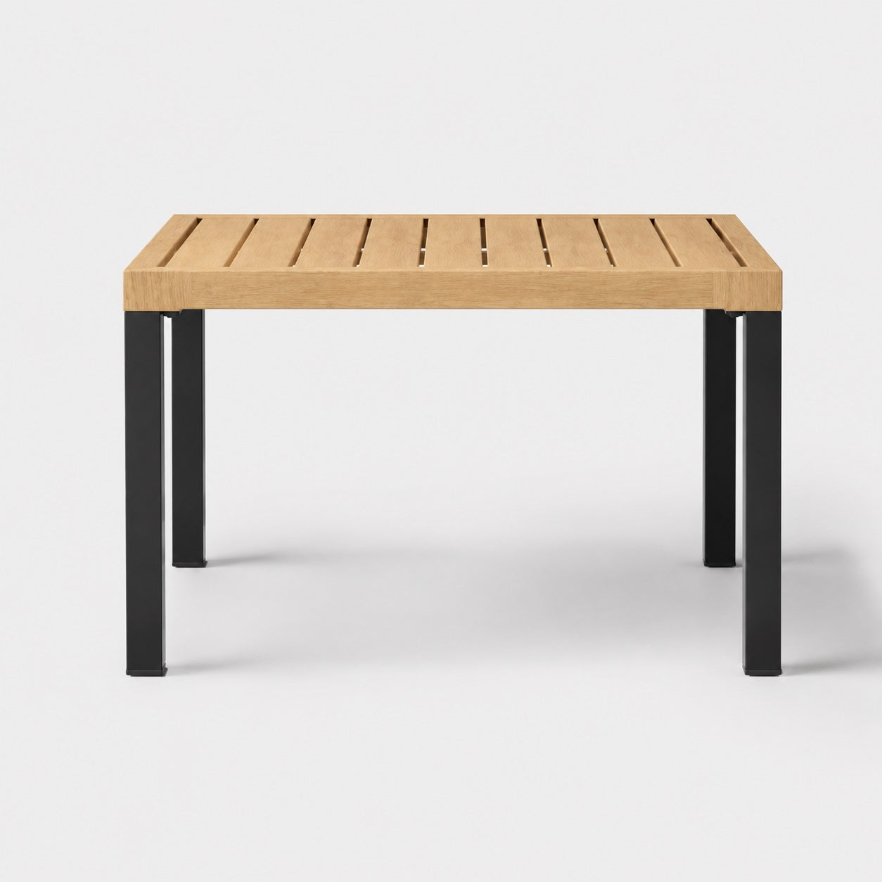 Table basse de jardin rectangulaire en bois naturel et pieds noirs, style moderne d’extérieure épuré.