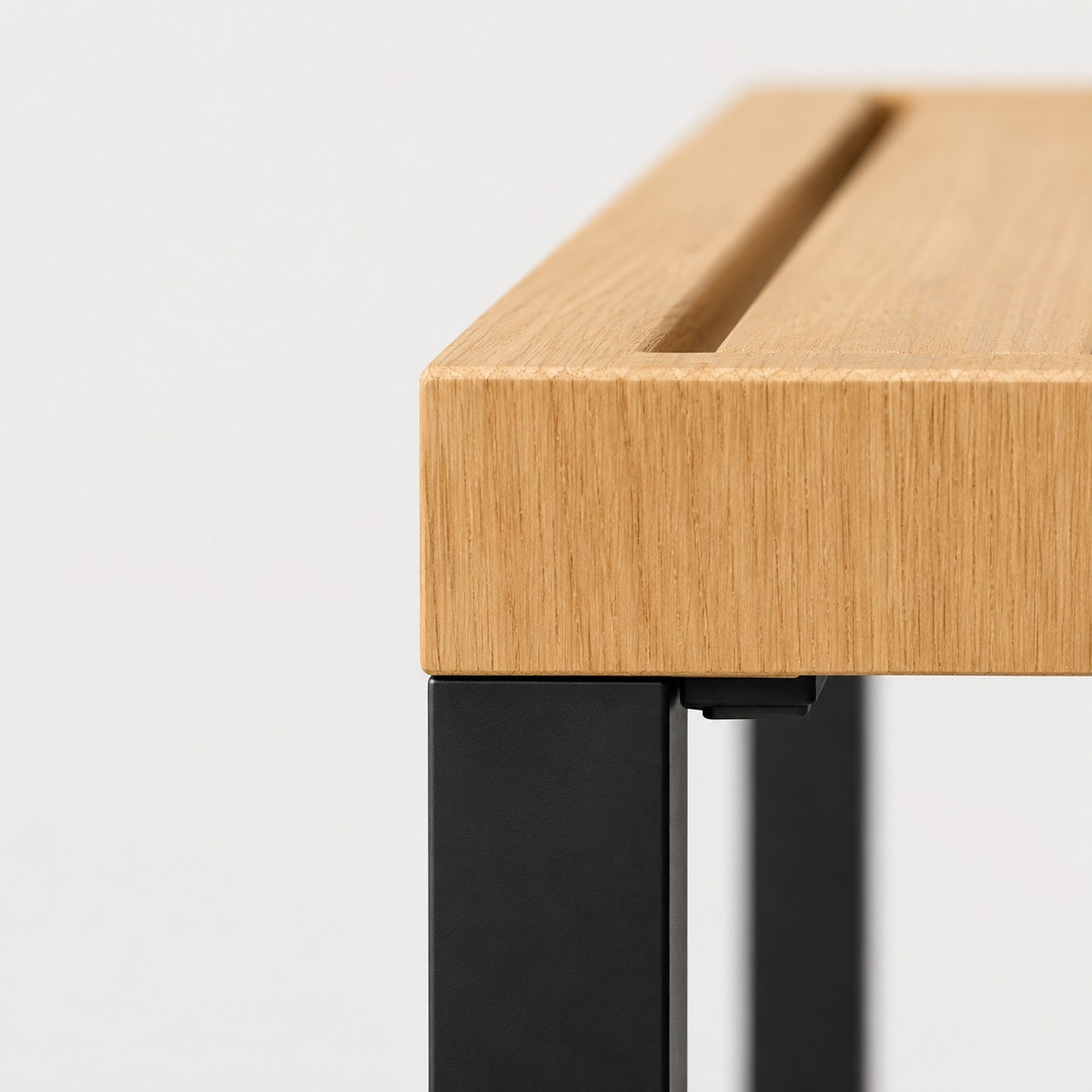 Détail bois naturel et structure noire de table basse de jardin d’extérieure au design moderne et élégant.