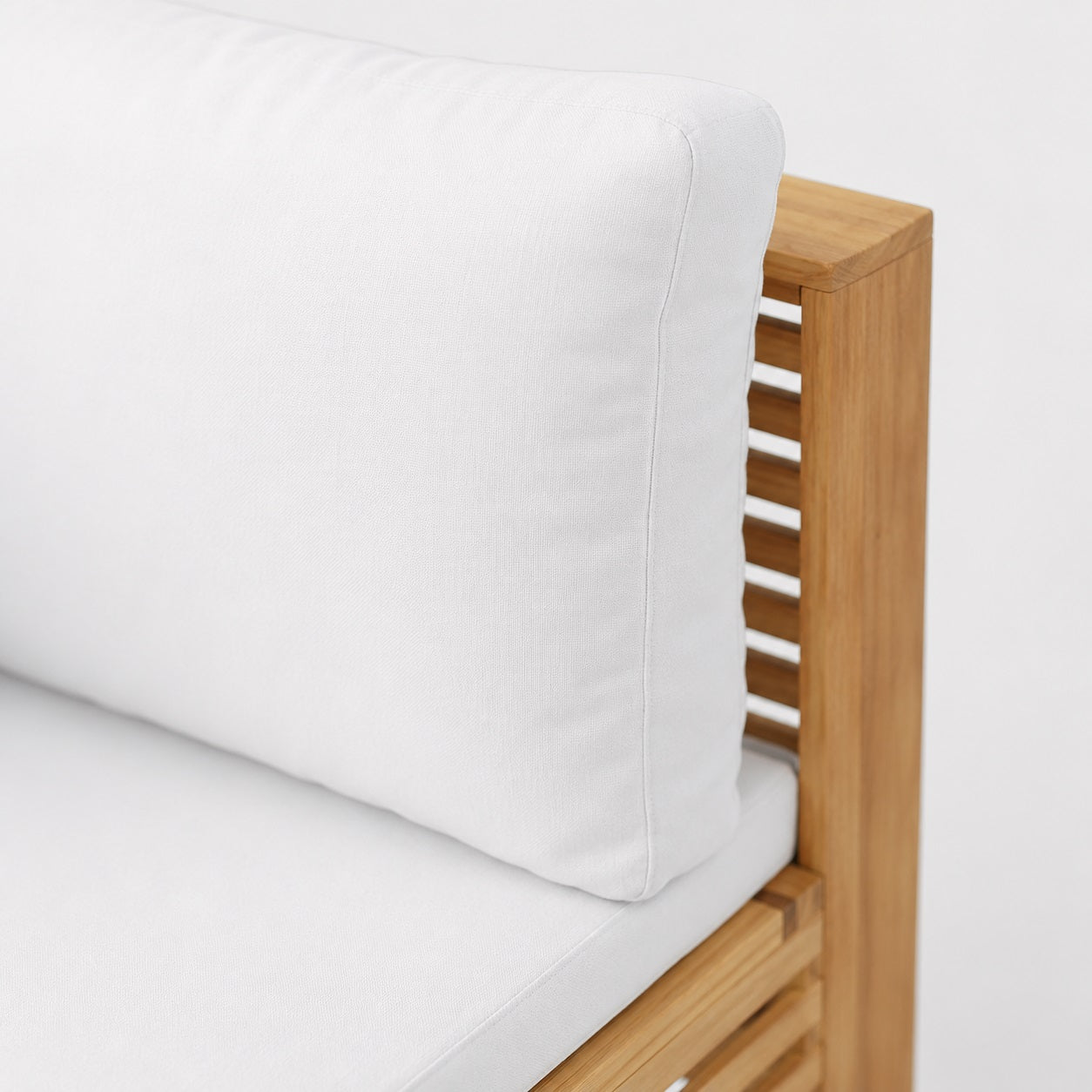 Détail coussin blanc et structure bois, table basse de jardin et mobilier d’extérieure contemporain