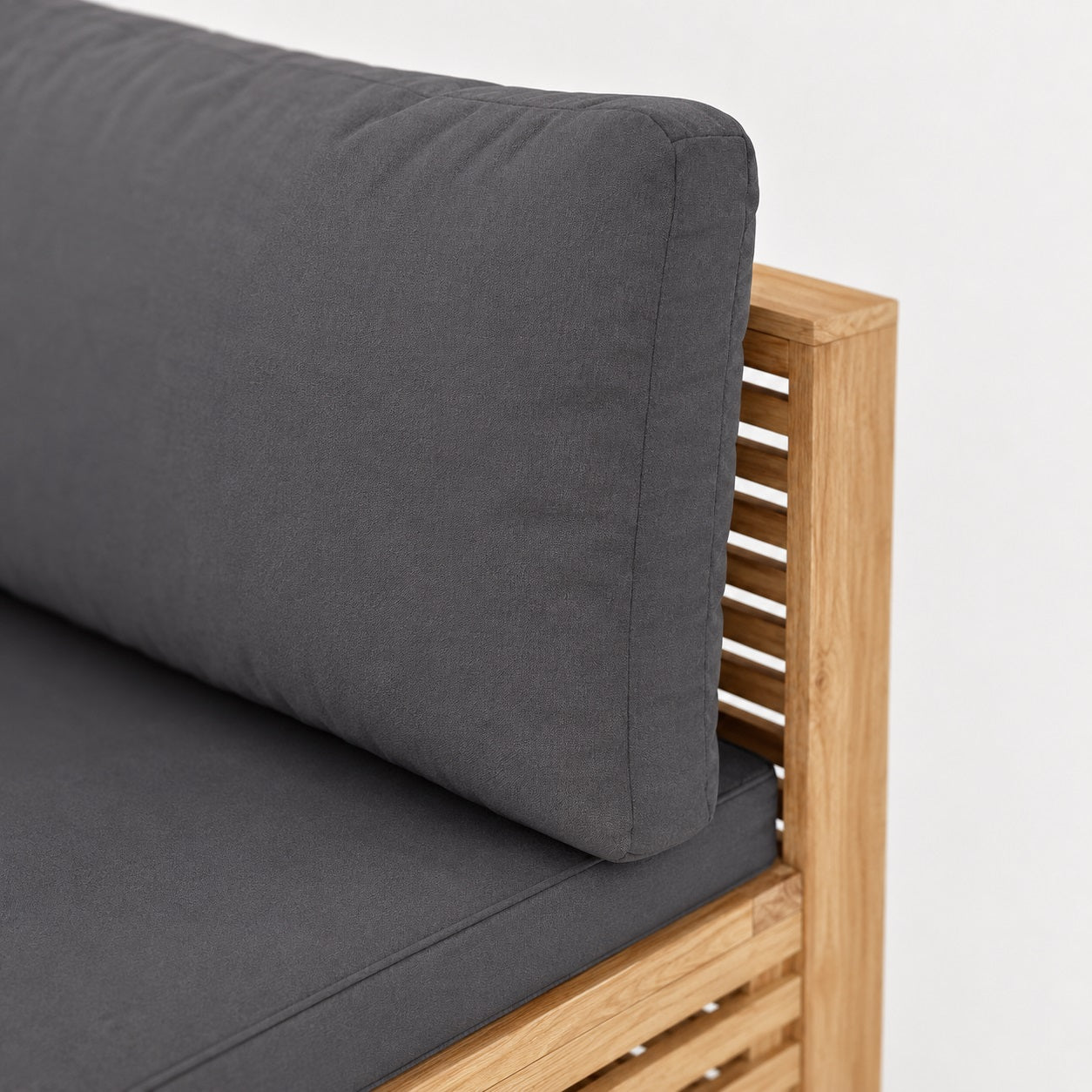 Zoom sur coussin gris et structure bois, table basse de jardin et mobilier d’extérieure haut de gamme