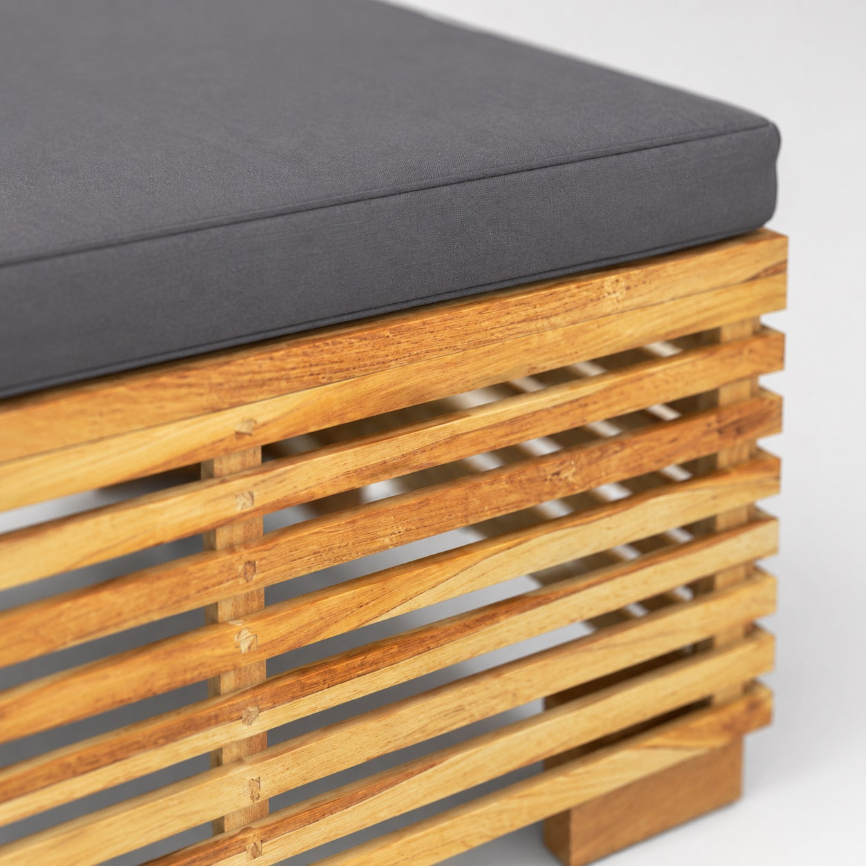 Détail coussin gris et structure bois, table basse de jardin et mobilier d’extérieure design moderne
