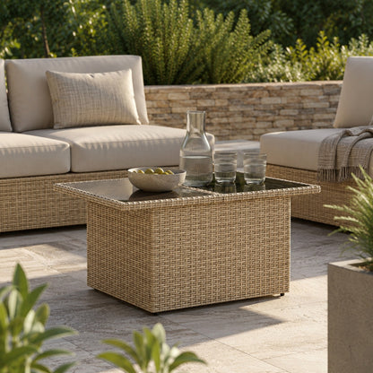 Table basse d'extérieur beige en résine tressée avec plateau verre dans un salon de jardin élégant