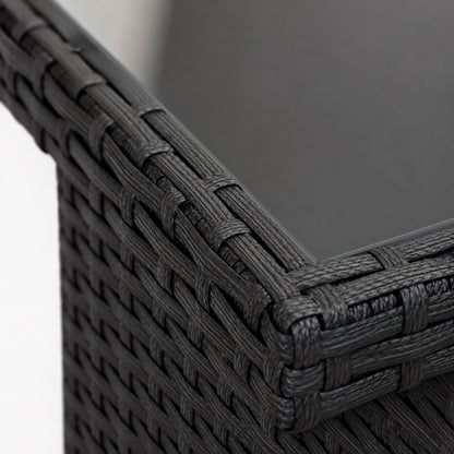 Zoom sur le tressage noir d’une table basse d'extérieur avec plateau en verre fumé moderne
