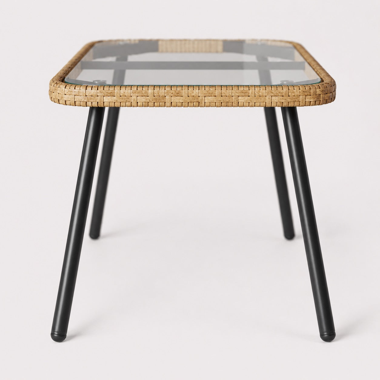 Table basse d’extérieur Nevara beige vue latérale avec plateau en verre et pieds noirs.