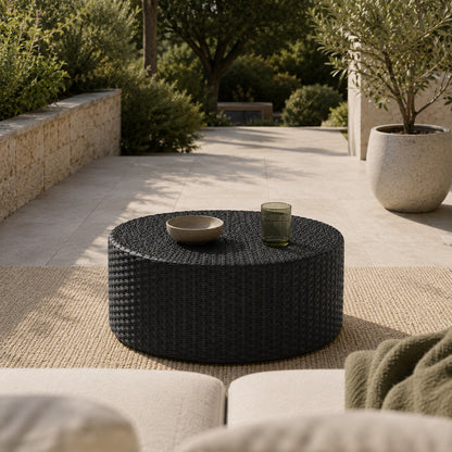 Table basse de jardin Oria noire ronde dans un espace d’extérieure contemporain et chaleureux