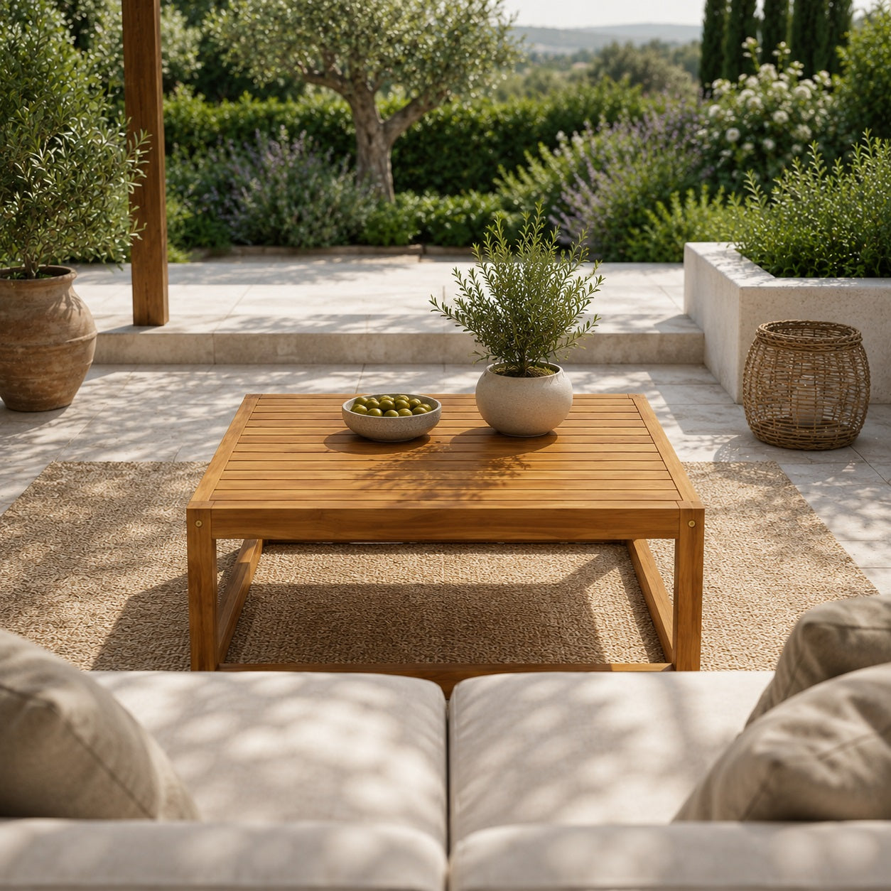 Grande table basse de jardin en bois naturel au centre d’un salon d’extérieur contemporain avec ambiance chaleureuse et méditerranéenne.