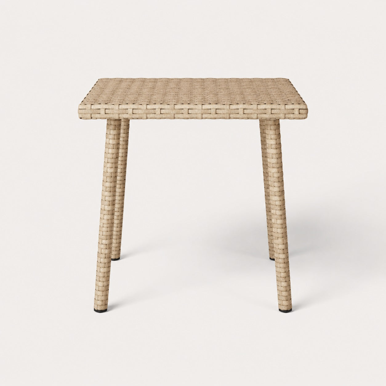 Vue de face d’une table basse de jardin carrée beige en résine tressée pour extérieur contemporain