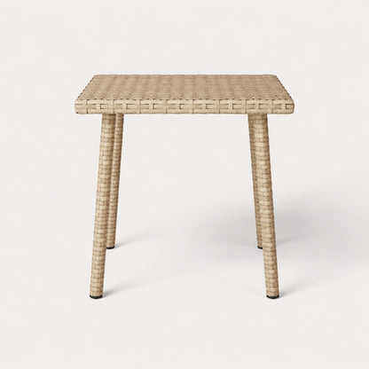 Vue de face d’une table basse de jardin carrée beige en résine tressée pour extérieur contemporain