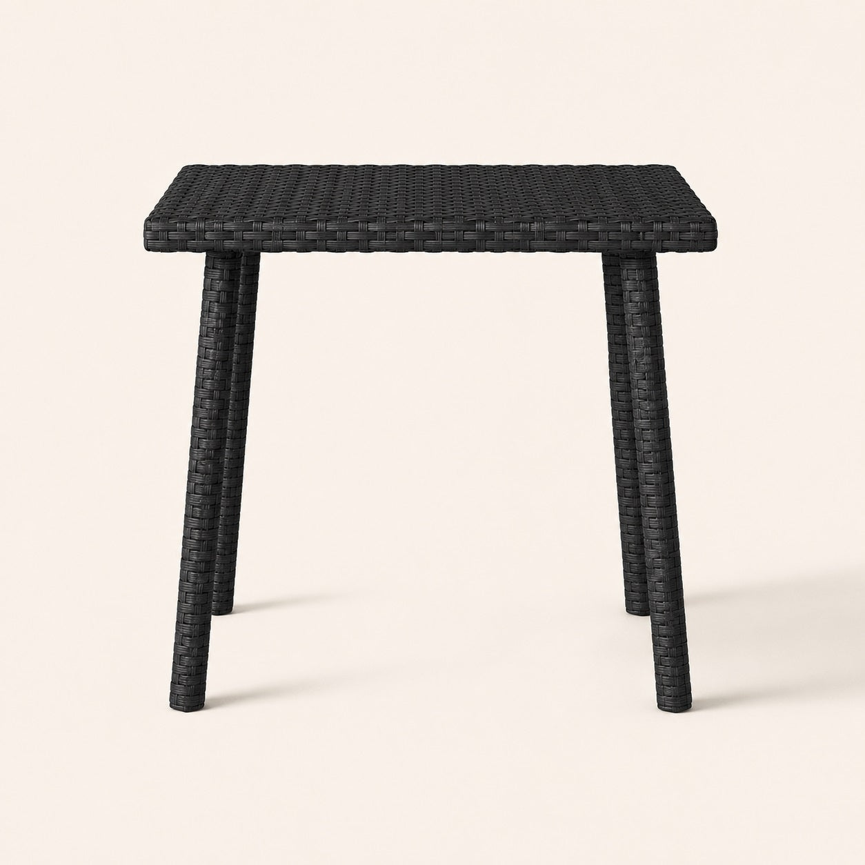 Vue de face d’une table basse d’extérieur noire en résine tressée pour jardin contemporain