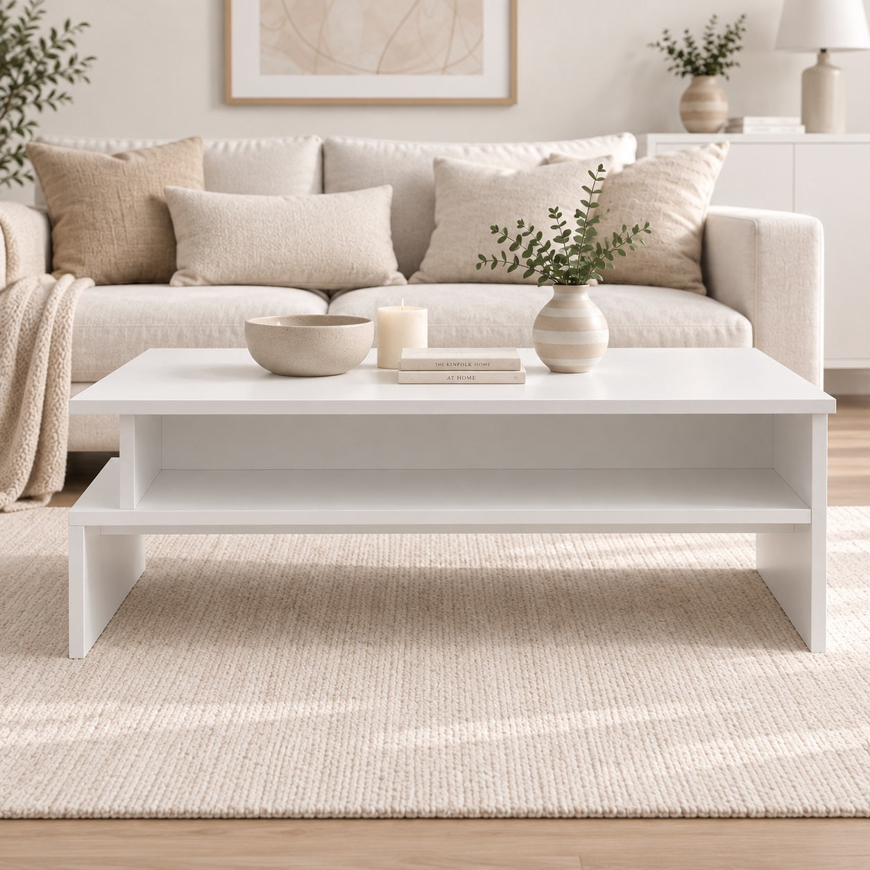 Table basse de salon blanche avec étagère de rangement, vue de face dans un intérieur moderne aux tons naturels.