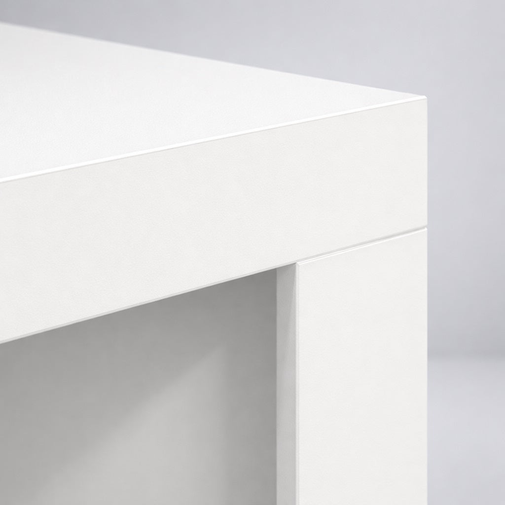 Gros plan sur le plateau d’une table basse blanche, finition mate et lignes épurées pour salon.