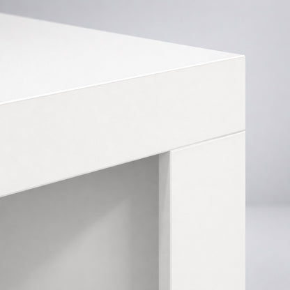 Gros plan sur le plateau d’une table basse blanche, finition mate et lignes épurées pour salon.